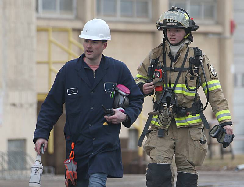 A Carus Chemical employee walks out of the plant with an Oglesby firefighter on Wednesday, Jan. 11, 2023 in La Salle.