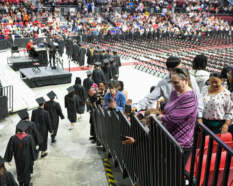 Friends and family watch as graduates file into Northern Illinois University Convocation Center on Saturday, May 24, 2025, during the Class of 2025 Commencement ceremony.