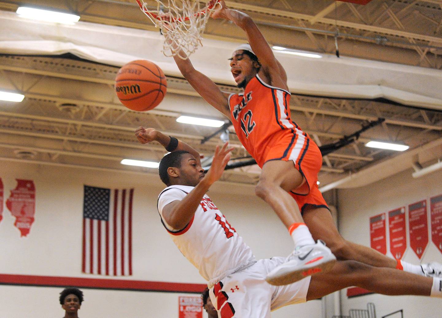 Romeoville's Troy Cicero, Jr (12) slams the ball over Yorkville defender Jovaughn Brown during a boys' basketball game at Yorkville High School on Tuesday, Jan. 10, 2023.