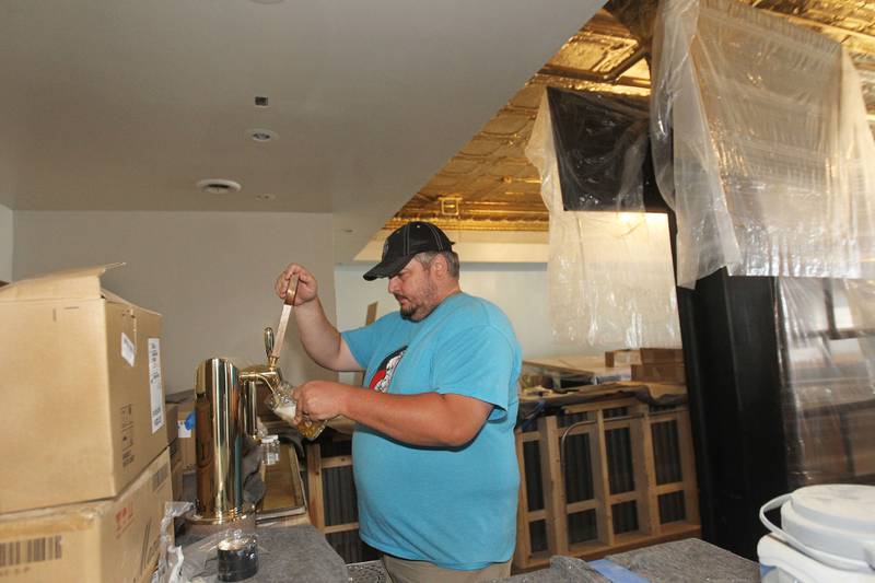 Joshua Grubbs, president/brewer, gets some craft beer from the draft tower at the Black Lung Brewing Company’s new location under construction in Fox Lake on Monday, June 26, 2023. The small brewery from Round Lake Beach has started a Kickstarter fundraiser called, Black Lung Expansion to Fox Lake. One of the prizes for Kickstarter includes Mug Legion Member for Life. The grand opening for the Black Lung Brewery Fox Lake located near Lakefront Park at 115 Nippersink Rd. is on July 22nd from 3-5pm. 
Image by Candace H. Johnson for Shaw Local News Network