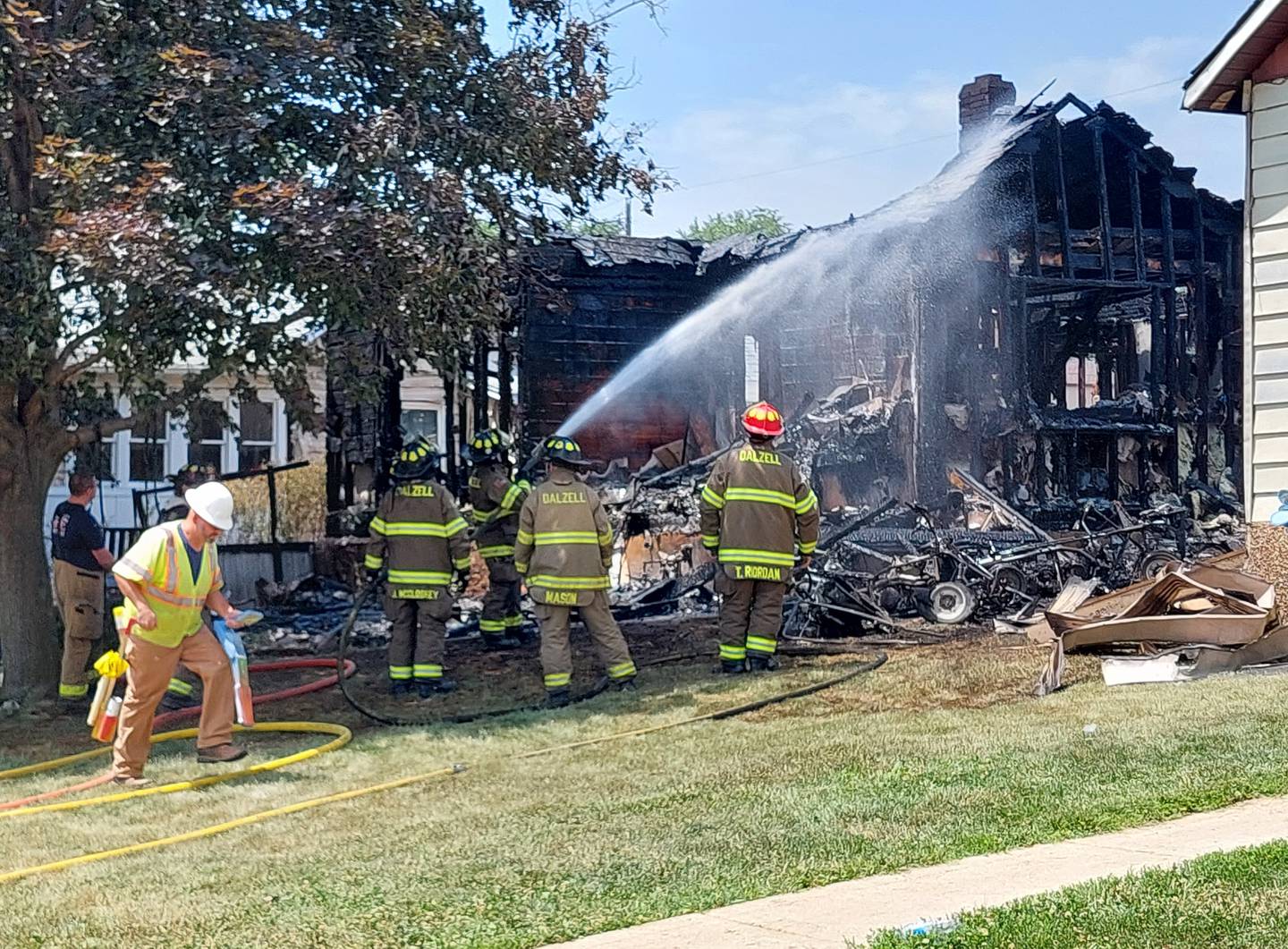 Firefighters spray hot areas Saturday, June 10, 2023, of a house that was a total loss on the 100 block of East Caroline Street in Spring Valley.