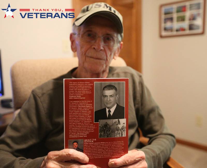 Marine corps Veteran Terry Fischer, holds a book about Vincent R. Capodanno Jr., M.M., a Catholic priest and Maryknoll Missioner killed in action while serving as a Navy chaplain with a Marine Corps infantry unit during the Vietnam War. Fisher served along side Capodanno in the Vietnam War.
