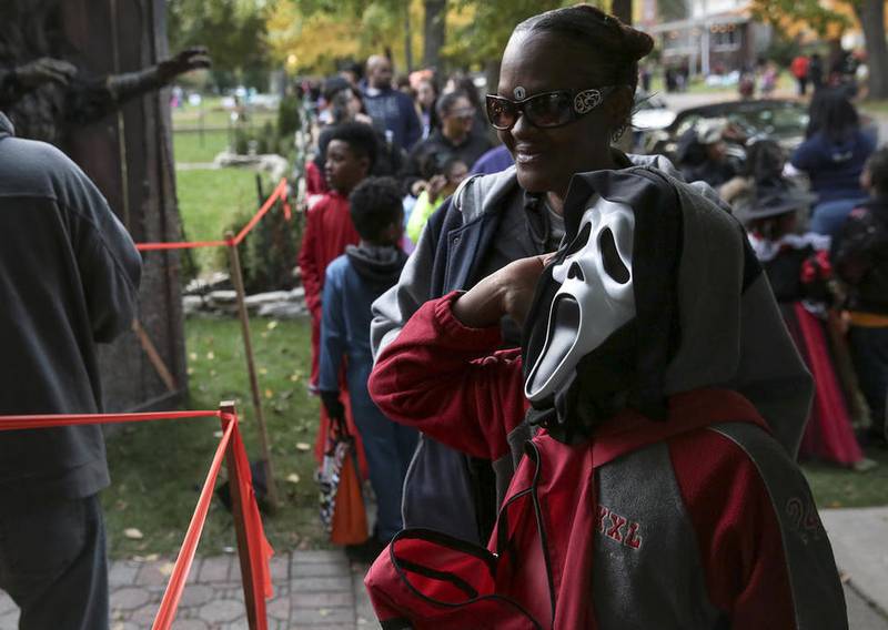 Several costume-clad children trick-or-treat wait outside Chris Miller's home Monday, Oct. 31, along Western Avenue in Joliet. The Millers, who have had a haunted house outside their home for over two decades, decided against having their annual theatrical production. (Photo by Eric Ginnard - eginnard@shawmedia.com)