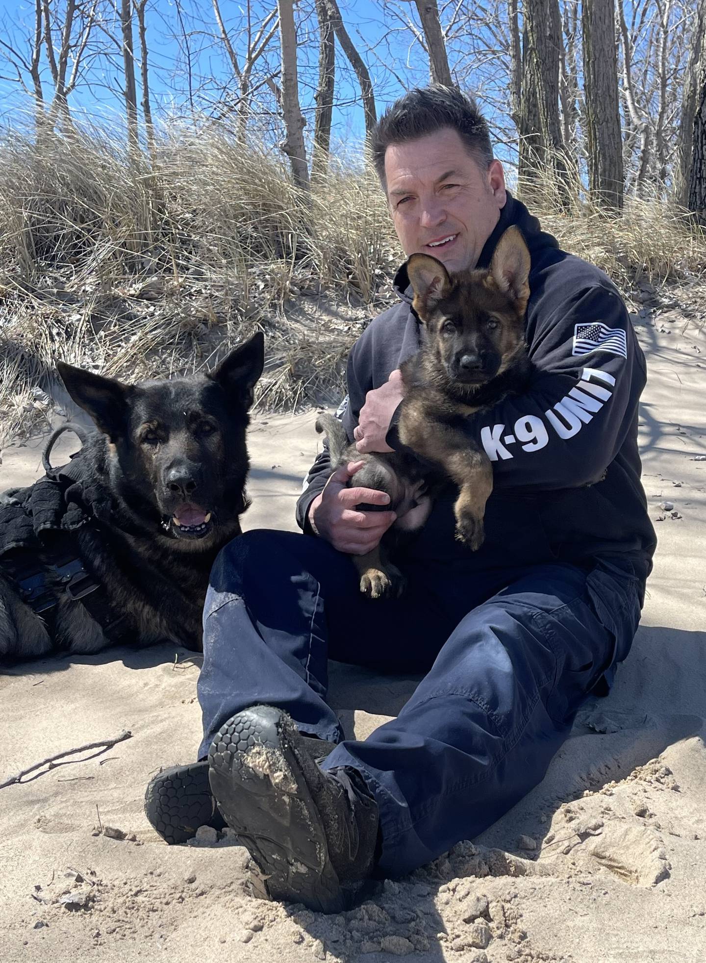 Lake County Sheriff's Deputy John Forlenza holds K9 Lux as a puppy. K9 Dax (left) is the puppy's father. Forlenza now will be partnering with K9 Lux after K9 Dax's death in 2024.