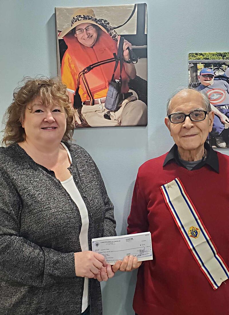 (From left) Tracy Wright, CEO of Gateway Services, receives a donation from Richard Bloch representing Father Peter E. Hand Knights of Columbus.