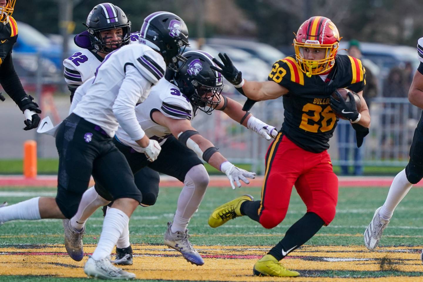 Batavia’s Nathan Whitwell (28) carries the ball against Downers Grove North's Jake Gregorio (34) during a class 7A quarterfinal playoff football game at Batavia High School on Saturday, Nov. 16, 2024.