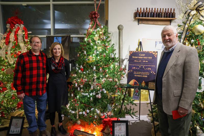 Camp Shaw-Waw-Nas-See board members Frank Cianci, left, Cynthia Veronda, center, and Bert Jacobson stand near the camp's decorated tree at the Kankakee County Museum during the 47th annual Gallery of Trees kickoff event on Wednesday, Dec. 3, 2025. The long-time camp celebrates its 80th anniversary next year, with sign ups already underway.