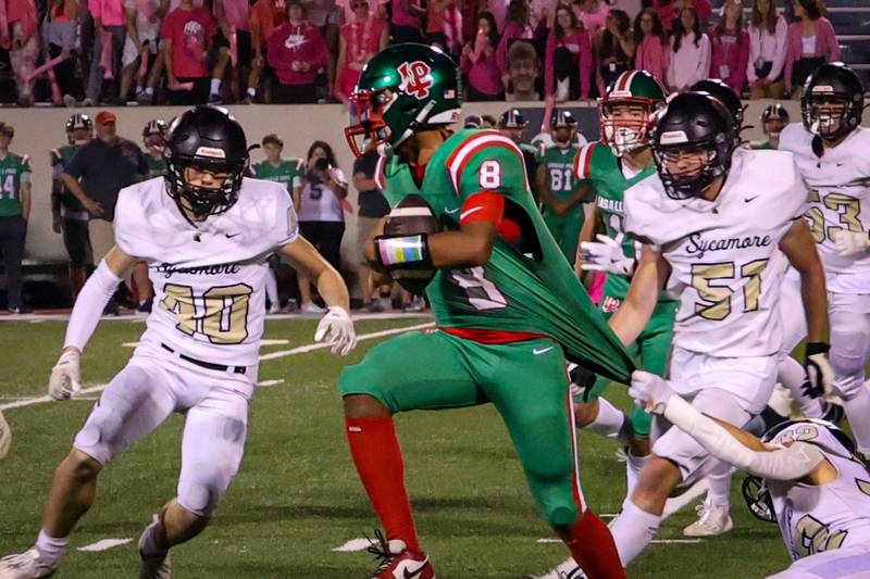 Marion Perich of L-P runs ball with jersey being held down by player of Sycamore on Friday, October 11, 2024 at Howard Fellows Stadium in LaSalle.