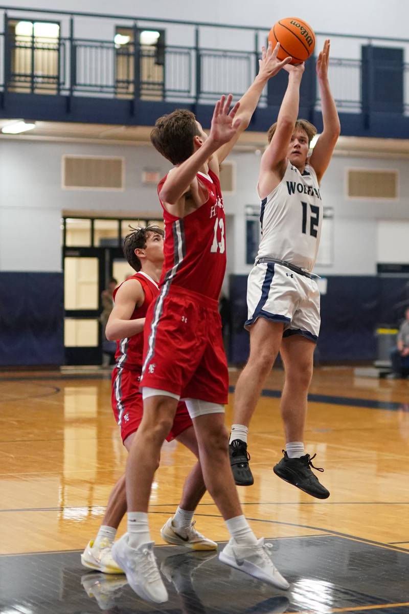 Oswego East's Lukas Adolfs (12) shoots the ball against Hinsdale Central during a hoops for healing tournament basketball game at Oswego East High School on Tuesday, Nov. 26, 2024.