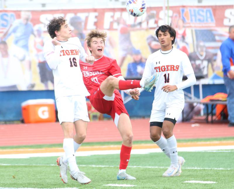 Hinsdale Central's Matt Gantar gets in between Edwardsville defenders Ben Leardi and Kaveen Shrestha to come up with the ball during the Class 3A State third place game on Saturday, Nov. 9, 2024 at Hoffman Estates High School.