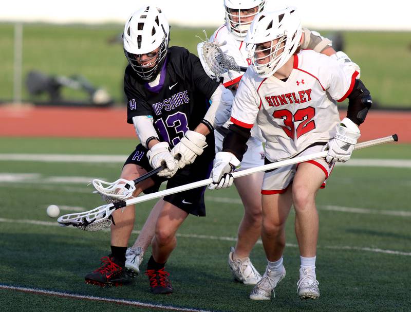 Huntley’s Trace Tedesco, right, battles Hampshire’s Conrad Coleman in varsity lacrosse at Huntley Thursday night.