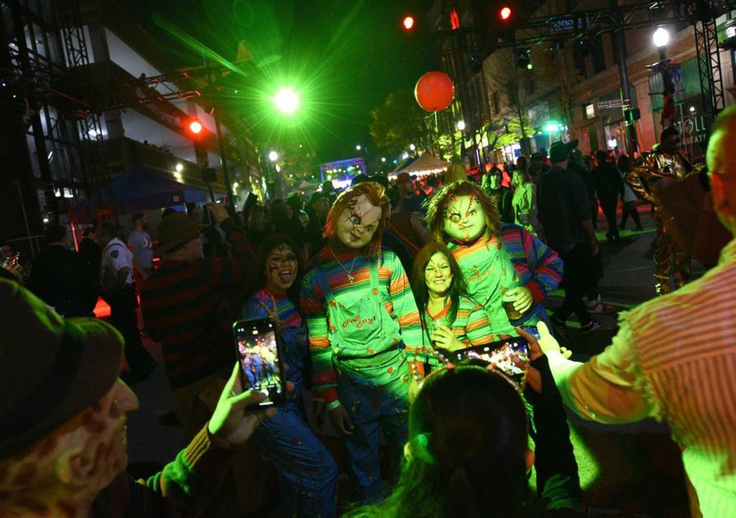 Festivalgoers snap photos of a group of Child's Play fans Saturday during Nightmare on Chicago Street in downtown Elgin