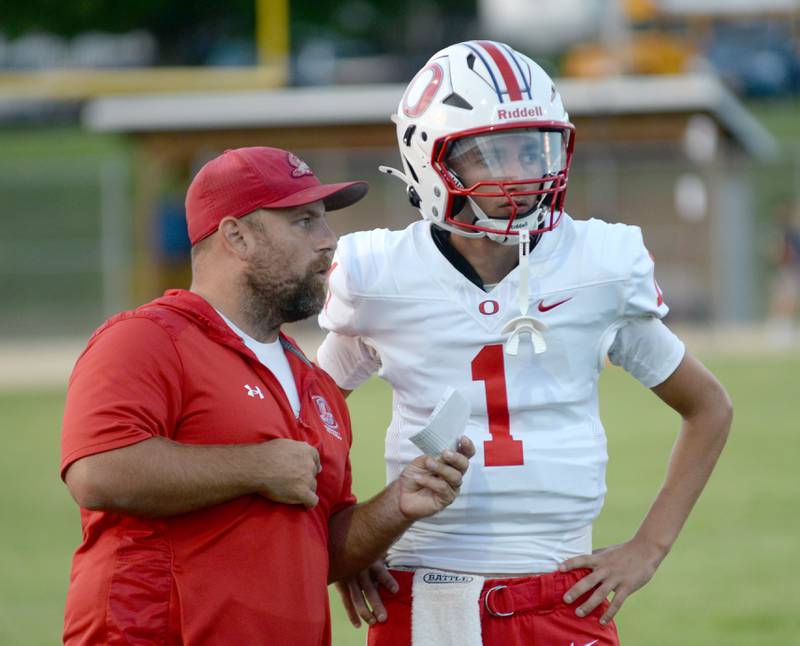 Oregon quarterback Benny Olalde talks with head coach Broc Kundert during a practice game with Eastland-Pearl City on Friday, Aug. 22, 2025 at Lanark.