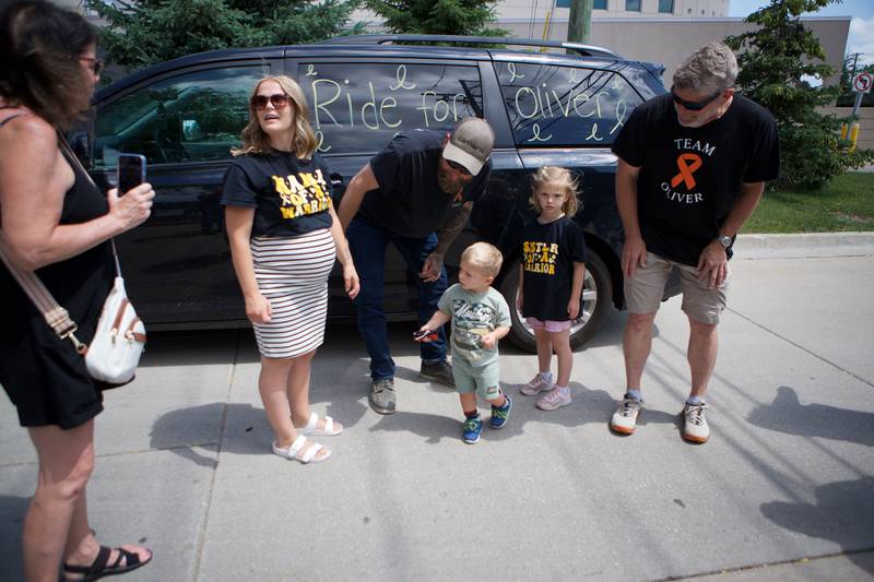 Mom Sami Olinger (second from left), Dad Nathan Olinger, 2-year-old Oilver Olinger and sister Maive Olinger arrive with family outside Sycamore Public Library for "Rally for Oliver," a parade meant to support Oliver on Sunday, June 22, 2025, as he was escorted by first responders to the St. Charles Motorcycle Museum.
