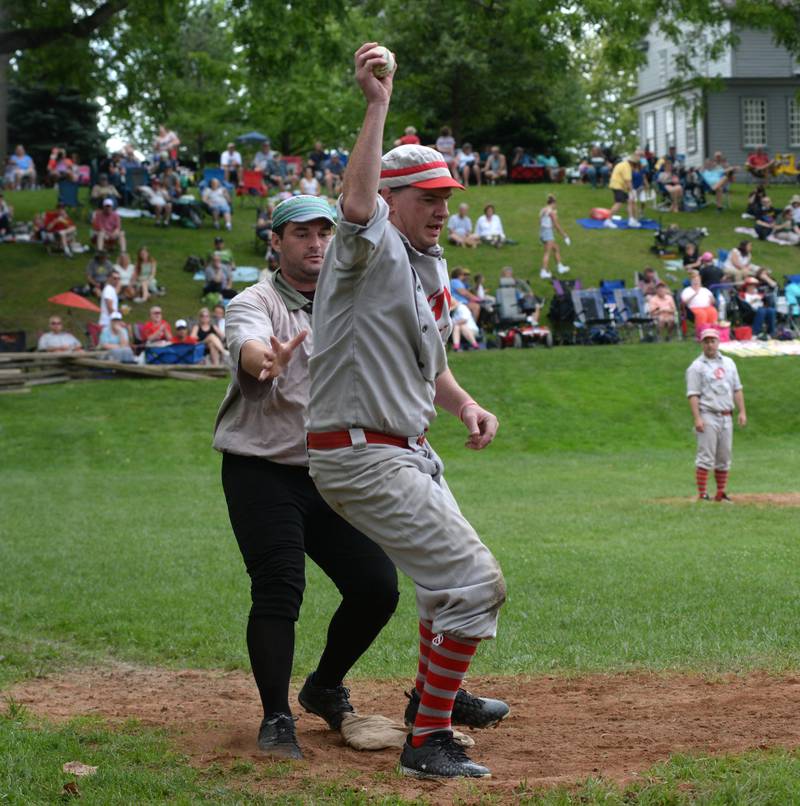 Ganymede first baseman Scott Tilton  holds the ball high in the air to show the umpire that he caught the ball for an out during Sunday, Aug. 13, 2023 action at the 20th Annual World Tournament of Historic Base Ball.