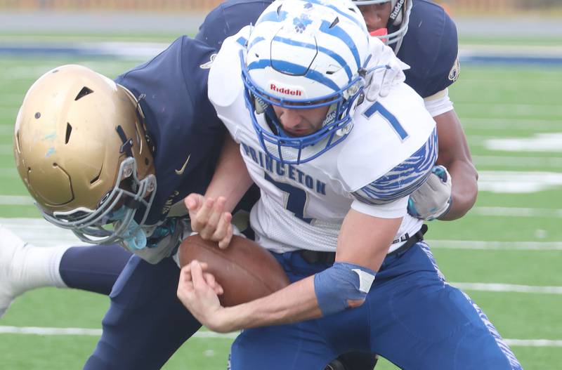 Princeton quarterback Gavin Lanham is brought down By a pair of Central Catholic players durring the Class 3A playoffs on Saturday, Nov. 1, 2025 at Central Catholic High School in Bloomington.