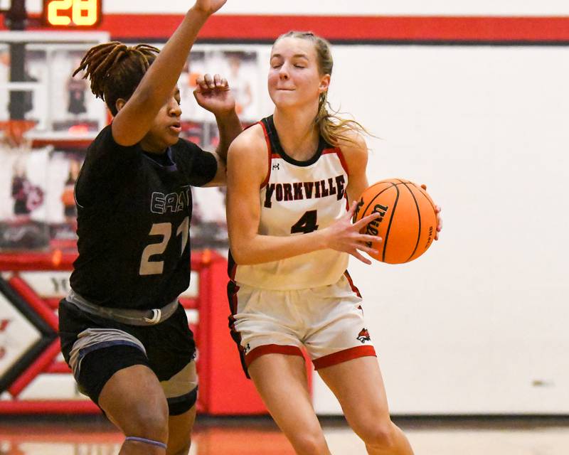 Yorkville's Macie Jones (4) drives to the basket while being defended by Oswego East's Desiree Merritt (21) during the game on Thursday Dec. 18, 2025, held at Yorkville High School,