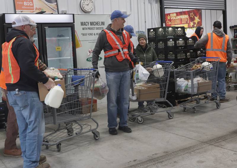 Volunteers prepare to load cart fulls of food into trunks during the Thanksgiving distribution on Wednesday, Nov. 19, 2025 at the Hall Township Food Pantry in Spring Valley. Nearly 500 families will receive food from this years distribution.