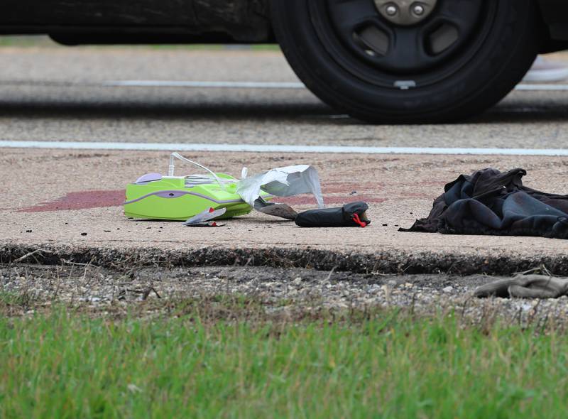 Debris, clothing and apparent blood sit on the road near a Honda sedan with a shattered window in the westbound lanes of Interstate 88 Monday, April 27, 2026, as police investigate an incident on I-88 just west of Keslinger Road in Maple Park.