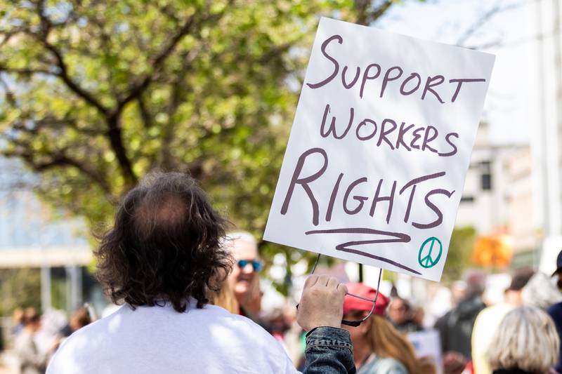 An attendee holds up a sign at the May Day Weekend Rally in Downtown Joliet on May 3, 2025.