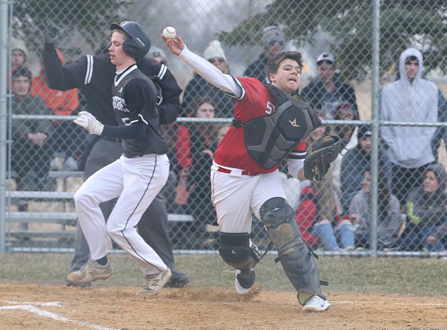 Streator's Logan Aukland throws to first base after forcing out Woodland/Flanagan-Cornell's Carter Ewing at home on Wednesday, March 15, 2023, at Woodland School.