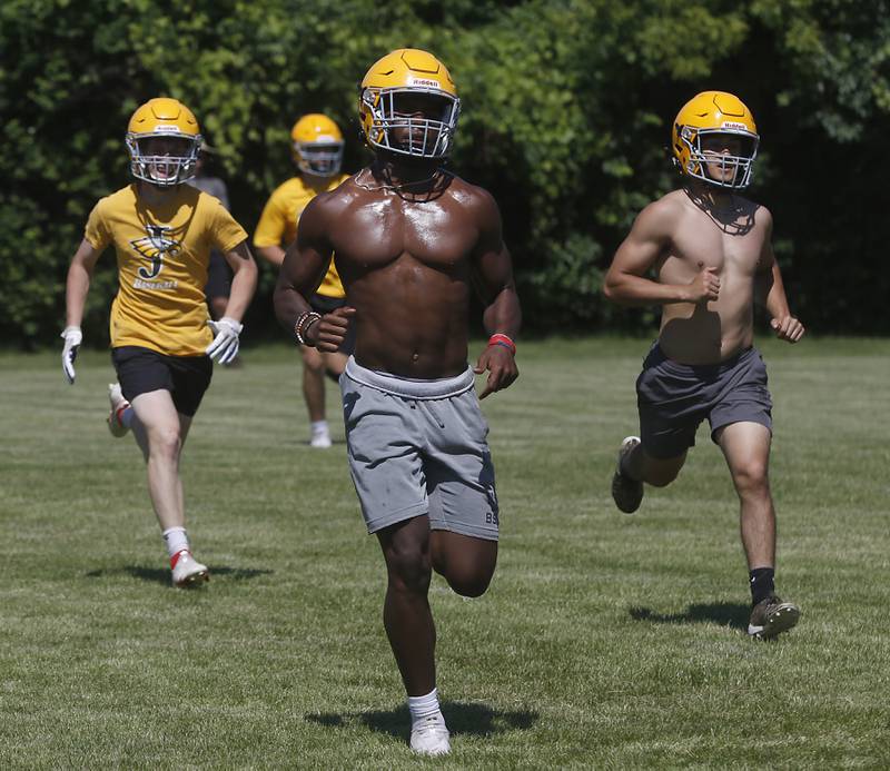 Running back Antonio Brown, center, runs with his teammates during football practice Monday, June 20, 2022, at Jacobs High School in Algonquin.