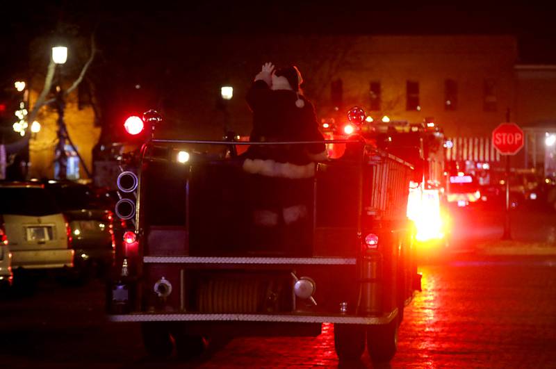Santa Claus waves to the crowd from a fire truck during the Lighting of the Square Friday, Nov. 24, 2023, in Woodstock. The annual holiday season event featured brass music, caroling, free doughnuts and cider, food trucks, festive selfie stations and shopping.