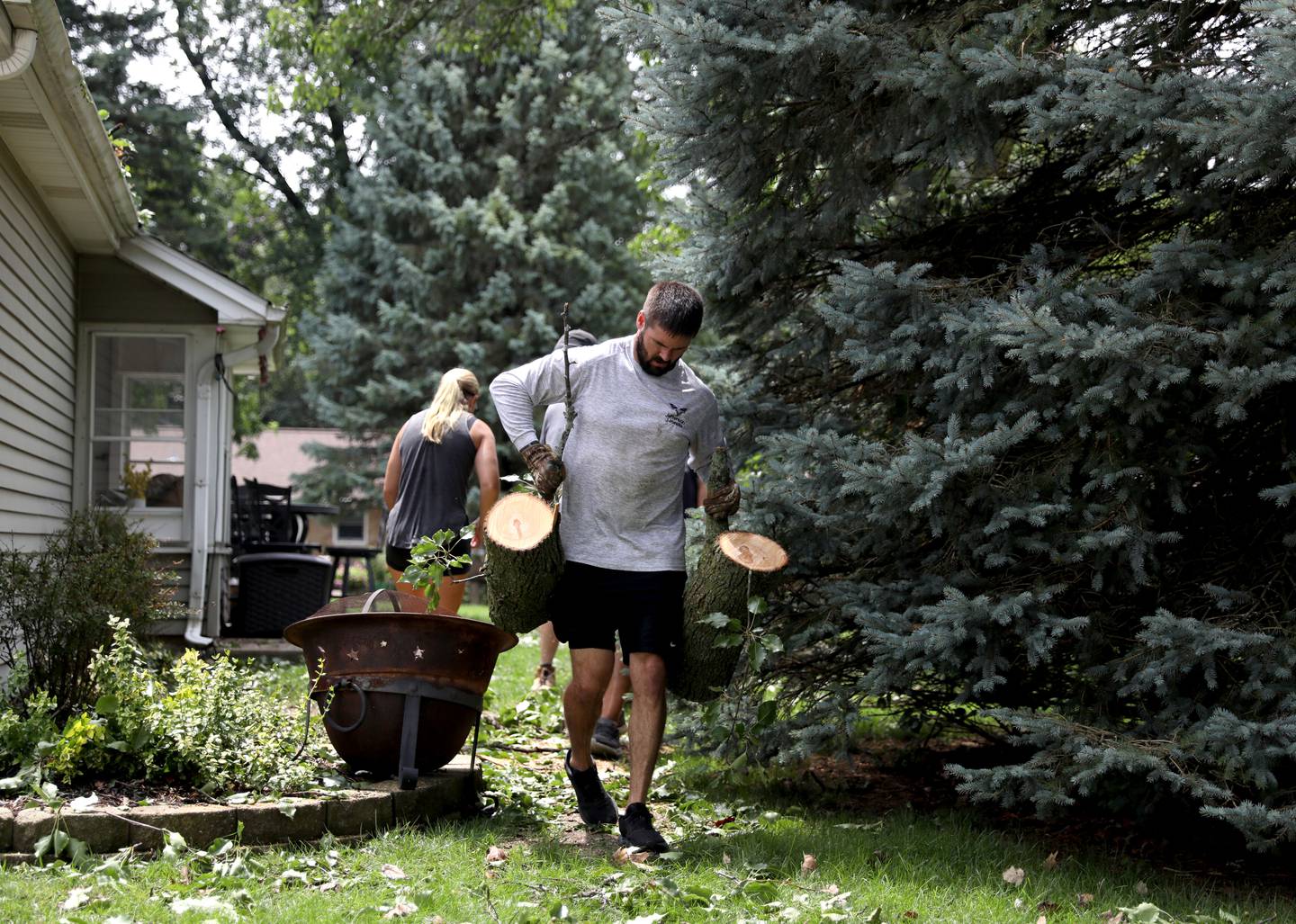 Cody Crawford helps clear a downed tree from the home of his brother and sister-in-law on Bastian Drive in Sugar Grove following storms ripping through the area the evening of Monday, July 15, 2024.