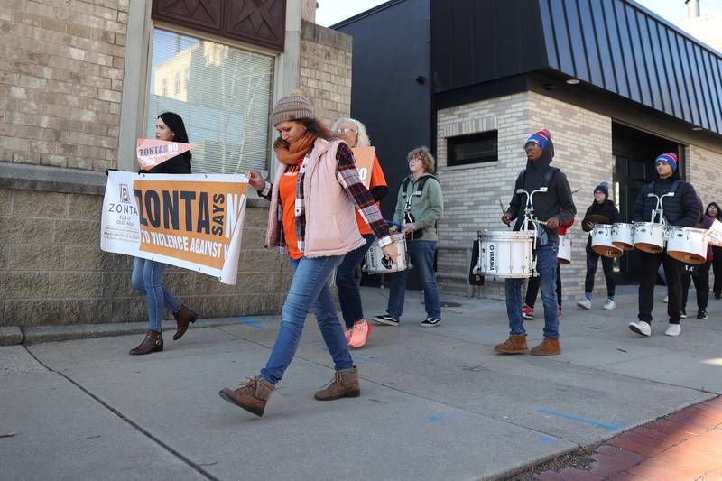 Supporters march along Chicago Street as Joliet Central’s drumline plays during a rally for ZONTA Says No To Violence Against Women on Tuesday in Joliet.
