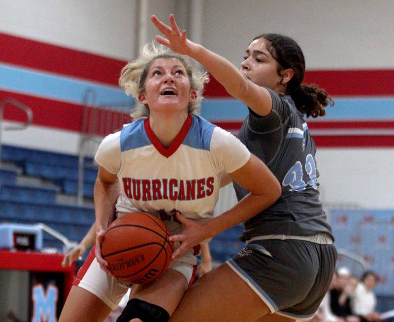 Marian Central’s Madison Kenyon works under the hoop against Rockford Guilford’s Nadia Barbour in varsity girls basketball Saturday at Landers Pavilion on the campus of Marian Central High School in Woodstock.