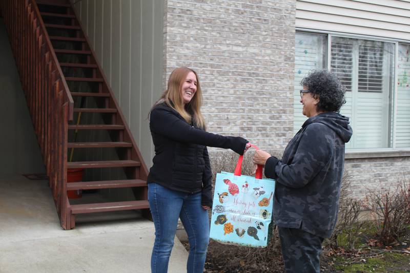 Buy Nothing Crystal Lake member Laura Miller hands off some free items to another Buy Nothing member in Crystal Lake.