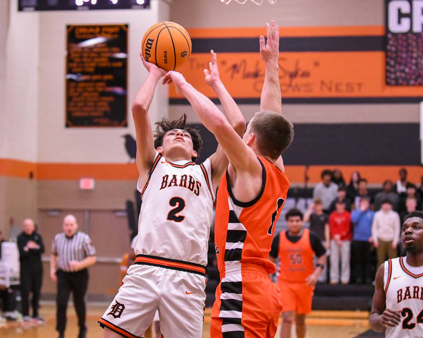 DeKalb's Aaron Ziga (2) makes a basket while being defended by United Township defender Leo Sim during the third place Dayton Tournament game on Tuesday Dec. 30, 2025, held at DeKalb High School.