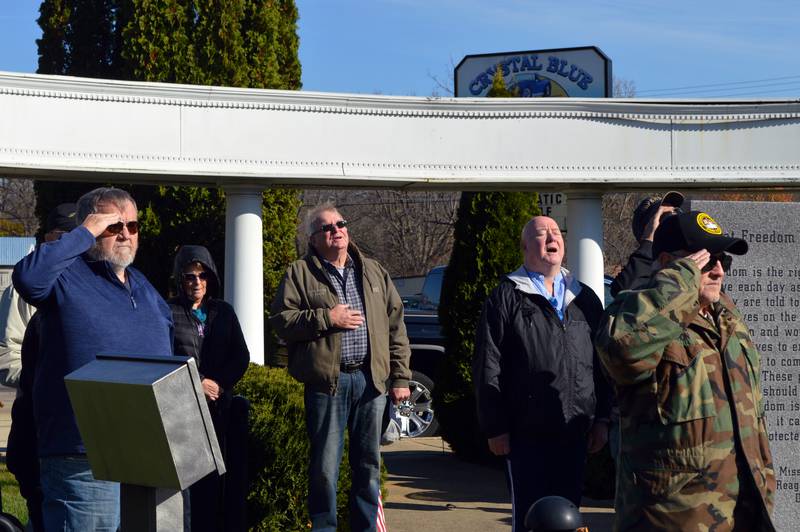 Attendees of a Veterans Day ceremony on Monday, Nov. 11, 2024, in Dixon's Veterans Memorial Park listen and sing along to the national anthem at the start of the event.