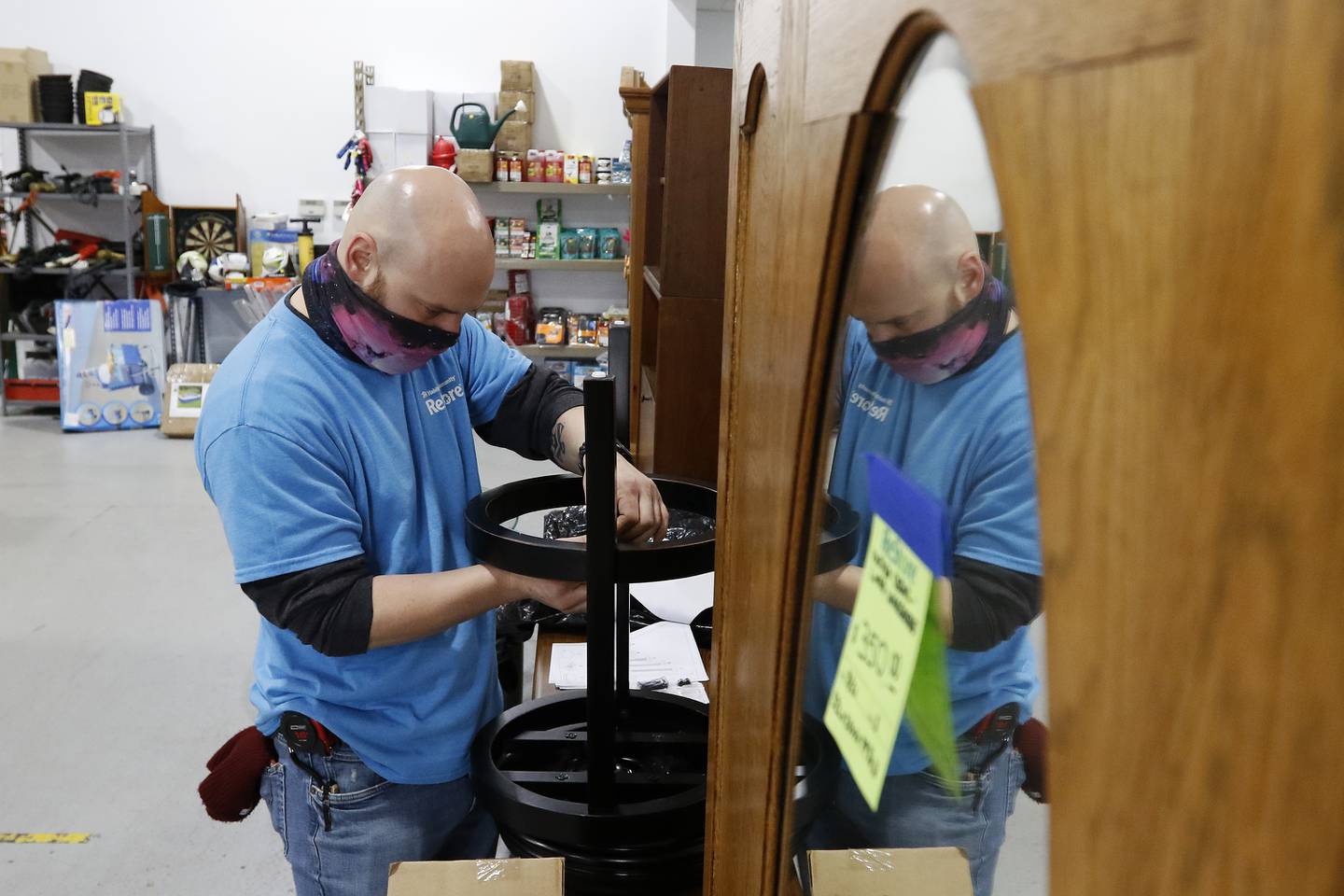 Connor Dziedzic works on rebuilding a bar stool on Thursday, Nov. 18, 2021, for resale purposes at the Habitat for Humanity ReStore location in Woodstock.  A backlog of supplies at many retail furniture and home decor stores has contributed to an increase in shoppers purchasing their home furnishings from antique, thrift, and secondhand stores.