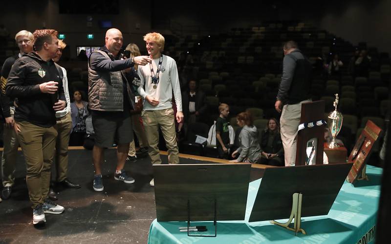 Players and family members look at the trophies during a celebration for the Crystal Lake South boys soccer team on Wednesday, Nov. 8, 2023, at Crystal Lake South High School. South defeated Peoria Notre Dame to win their second soccer state championship on Saturday.