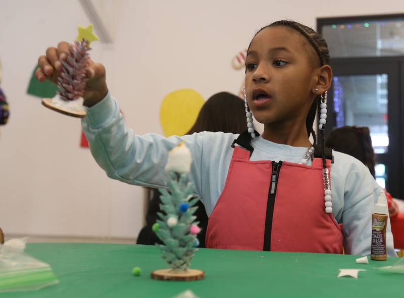 Nycole Jackson of La Salle, holds up her Christmas tree that she made during the Miracle on First Street at Ax Church on Saturday, Dec. 6, 2025 in La Salle.