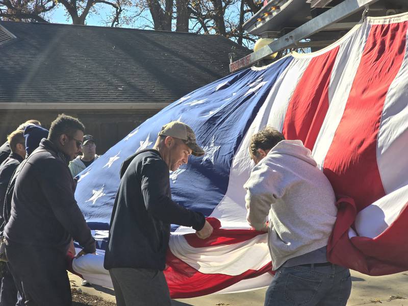 Streator firefighters fold up the large American flag Monday, Nov. 11, 2024, at City Park.