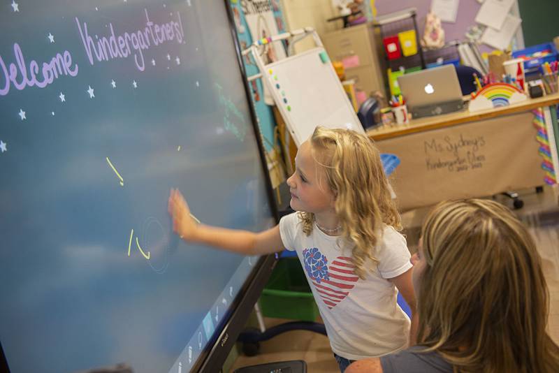 Addy McNitt, 5, clears away her drawing while checking out a new smart board in the kindergarten room at St.Anne’s School on Thursday, August 11, 2022.