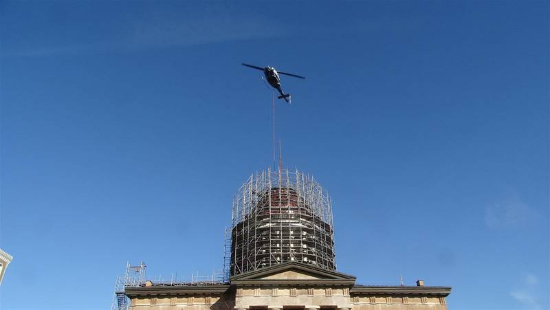 A helicopter is used to remove the flagpole from atop the Old State Capitol in Springfield on Monday morning as part of a renovation project to reinforce the dome and repair a leaky roof. (Capitol News Illinois photo by Peter Hancock)