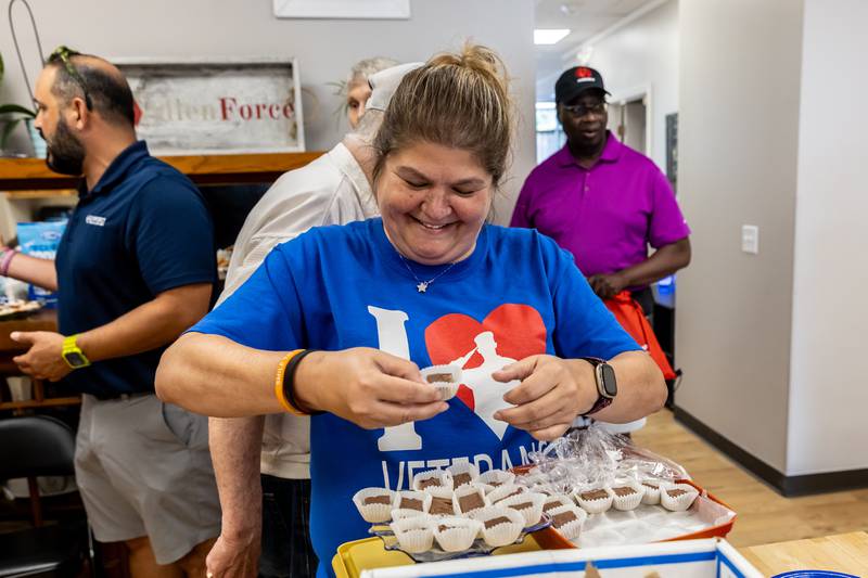 Volunteer Christine Leali-Perkins adds more refreshments to the festivities during AllenForce's grand opening event which introduced the community to the new Veteran Wellness & Recreation Center in Joliet on July 25, 2025.