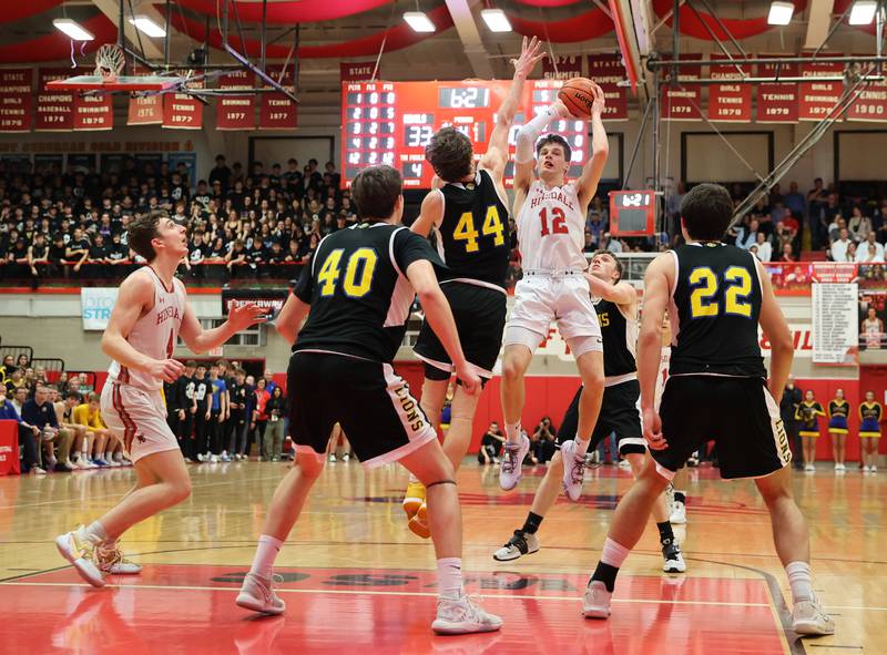 Hinsdale Central's Ben Oosterbaan (12) puts up a shot in traffic during the boys 4A varsity sectional semi-final game between Hinsdale Central and Lyons Township high schools in Hinsdale on Wednesday, March 1, 2023.