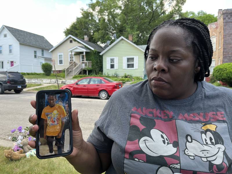 Tysha Hammond holds up a phone displaying a photo of her son, Antoine Shropshire, 16, who was shot and killed on Tuesday, May 30, 2023 in Joliet.