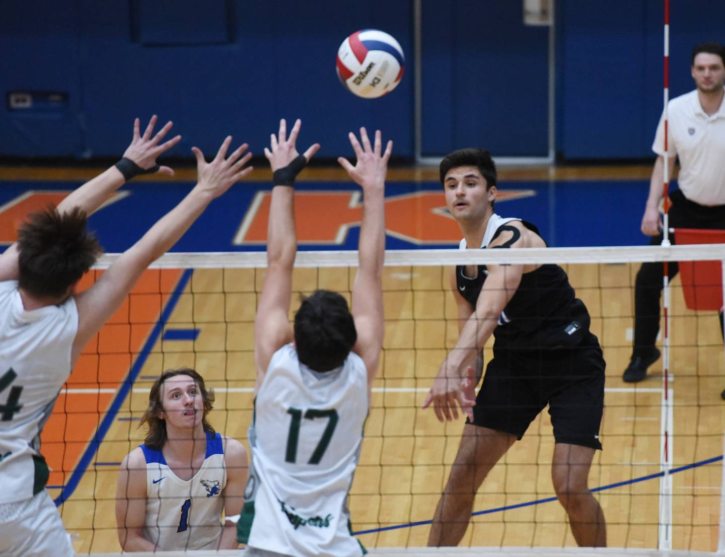 Paul Valade/pvalade@dailyherald.com
Lincoln-Way East's Jon Guch, right, hits into the Glenbard West defense during Saturday’s IHSA state boys volleyball championship match in Hoffman Estates.