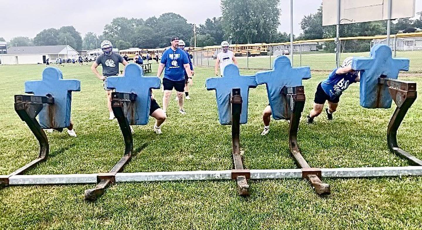 Princeton assistant coach Kirk Becker runs a drill on the blocking sled in last week's mini-camp. The Tigers will host their annual 7-on-7/Linemen's Challenge for Saturday, July 19. Dixon, L-P, Ottawa, Marquette and EPC will be among the participating schools.