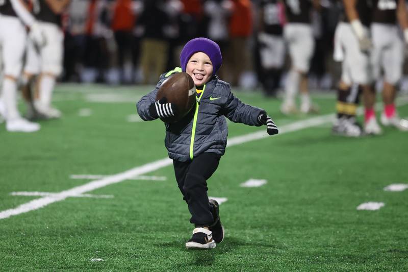 Ballboy Cooper Ericksen, 4-years old, runs the ball back to the sideline of Joliet Catholic during the game against Leo on Friday, Oct. 6, 2023 in Joliet.