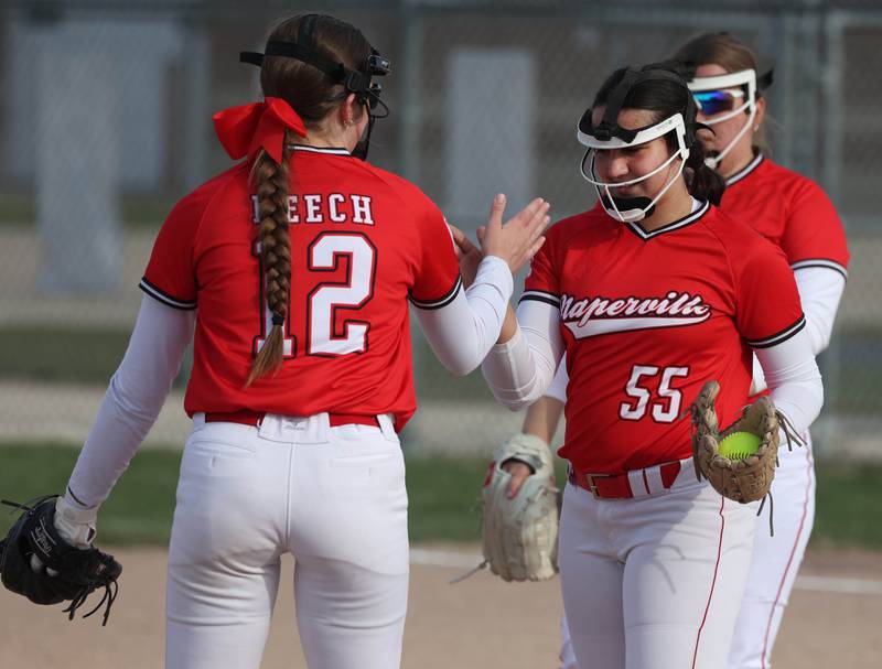 Naperville Central's Shea Meech (left) congratulates pitcher Avery Miller after a strikeout Wednesday, April 16, 2025, during their game at DeKalb High School.