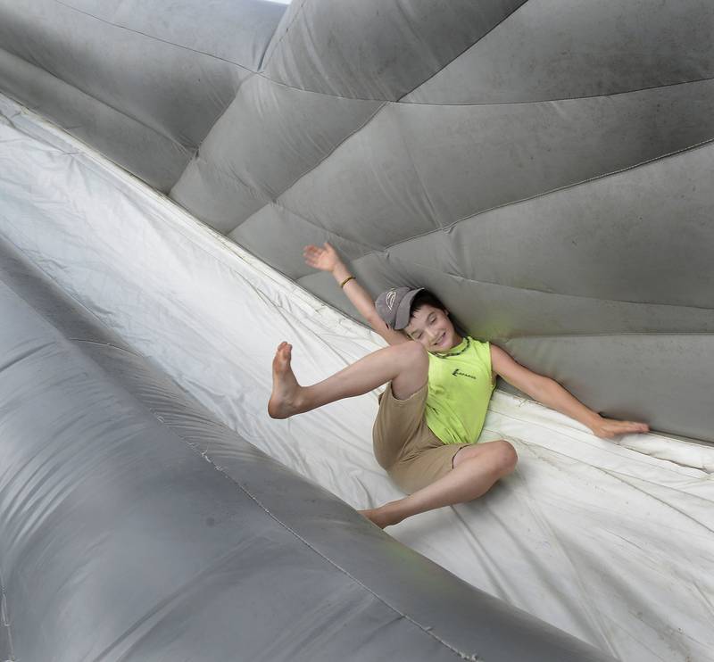 Dezlan Duncan takes a spill while going down an inflatable slide Wednesday, July 27, 2022, at the Ottawa City Recreation's game carnival at Rigden Park.