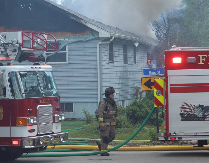 Firefighters work the scene of a structure fire as flames pour out of the roof in the 1900 block of Main Street on Monday, May 4, 2026 in Peru.