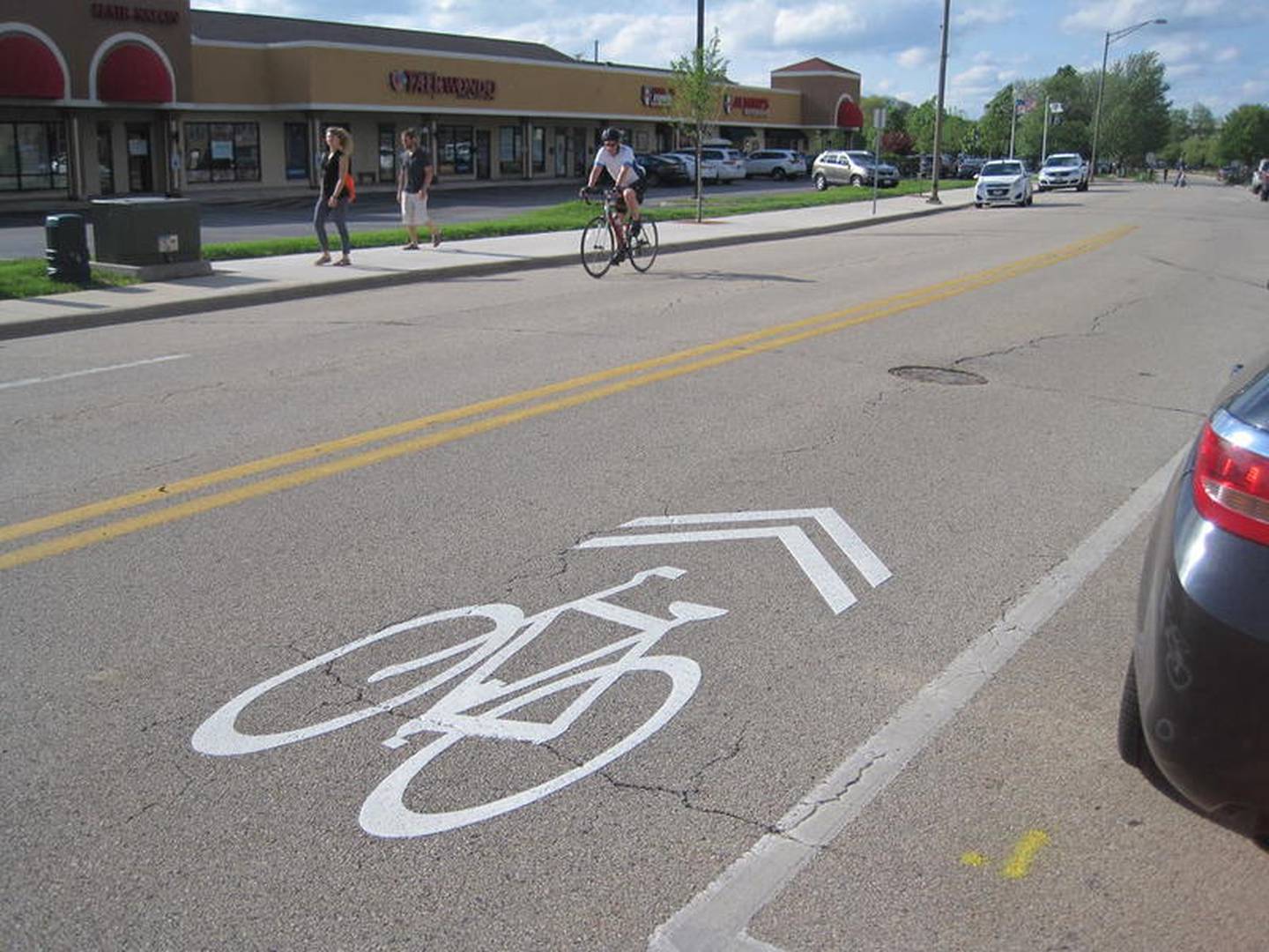 A bicyclist rides along Batavia's Island Avenue in a "sharrow," a shared lane for both bicycles and motor vehicles. The pavement marking in the foreground designates a shared lane. The city of Batavia has placed the markings along the length of Island and Shumway avenues to provide cyclists with a better link between the four legs of the Fox River Trail that converge in downtown Batavia.