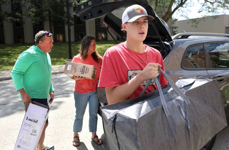 Jack Markhardt, an incoming freshman at Northern Illinois University from Rockford, gets a hand from his dad Kyle and mom Heather as he unpacks their car Wednesday, Aug. 21, 2024, in front of Patterson Hall during the first of two move-in days for new students at NIU in Dekalb.